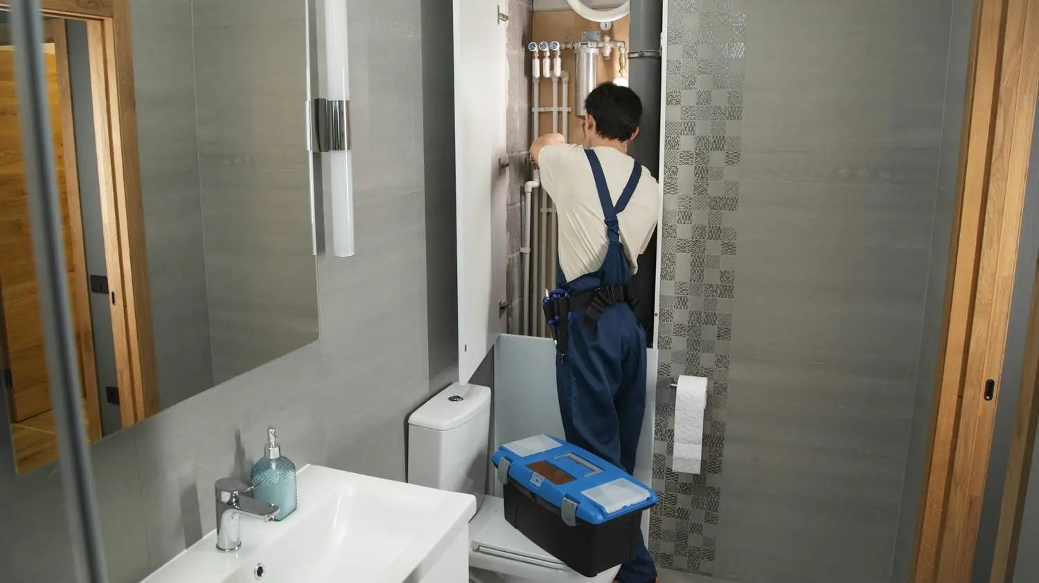 Plumber with a toolbox in a bathroom